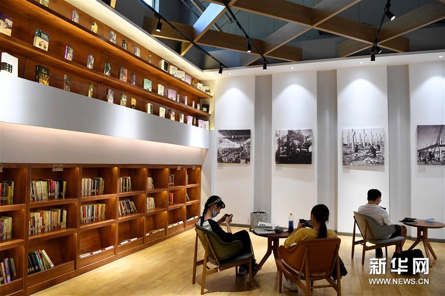 8月4日，在合肥长江180艺术街区，人们在由老厂房打造的拾光书屋里休闲。新华社发（解琛 摄）