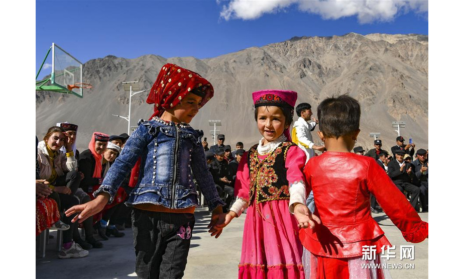 达布达尔乡热斯喀木村的小朋友在演出现场随着音乐跳舞（6月6日摄）。新华社记者 胡虎虎 摄
