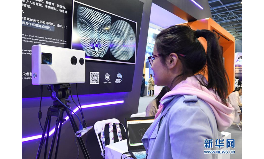 10月16日，在展览现场，工作人员在展示三维动态彩色扫描仪。新华社发（任超摄）