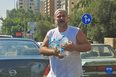 9月21日，在黎巴嫩贝鲁特一加油站前，一名男子在等待加油的车辆间售卖瓶装水。<br/><br/>　　9月22日，黎巴嫩能源部在不到一周的时间内第二次提高汽油价格，95号和98号汽油的价格上涨了15%左右。新华社记者 刘宗亚 摄