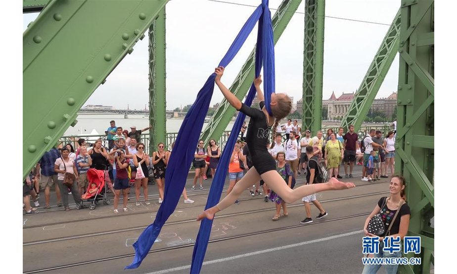7月21日，人们在匈牙利首都布达佩斯的自由桥上欣赏表演。新华社发（弗尔季·奥蒂洛摄）