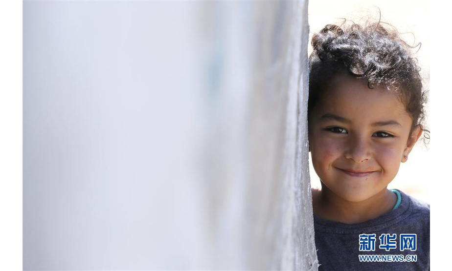 6月19日，在黎巴嫩东部贝卡谷地巴尔伊勒亚斯地区的一处叙利亚难民营，一名难民儿童在帐篷旁微笑。

　　叙利亚危机已进入第8年，不少为逃离战火来到黎巴嫩的叙利亚难民生活依旧。联合国难民署19日发布的最新报告显示，战争和其他形式的暴力使全球被迫流离失所者人数再创历史新高。这份名为《2017年流离失所问题全球趋势》的报告显示，截至2017年年底，全球被迫流离失所者人数为6850万，平均每110人中就有1人被迫流离失所。2017年有1620万人被迫流离失所。报告显示，就难民人数与本国人口的比例而言，黎巴嫩是全世界接受难民比例最高的国家。

　　新华社发（比拉尔·贾维希摄）