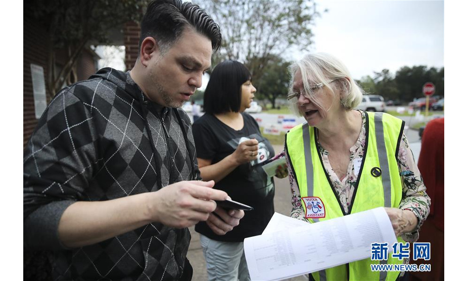 11月6日，工作人员在美国得克萨斯州休斯敦的一个投票站外帮助选民查询信息。美国6日举行2018年中期选举。 新华社记者 王迎 摄