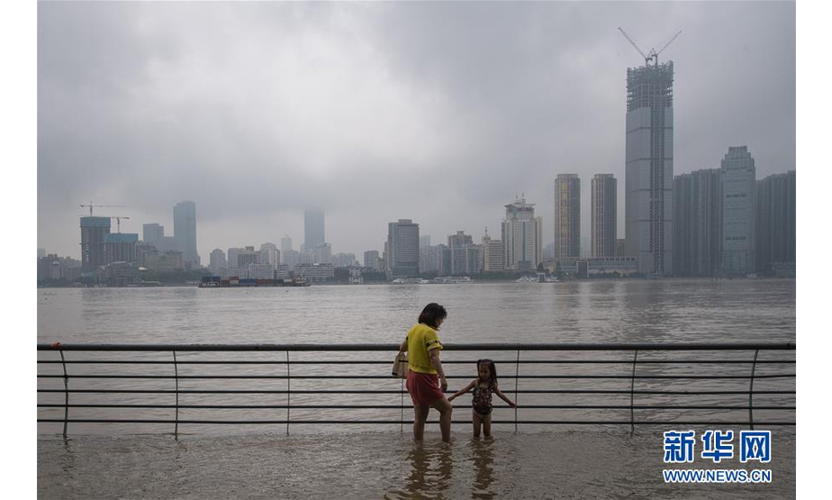 7月6日，市民在武昌江滩玩耍。 受持续强降雨影响，两湖水系及长江中下游干流区间来水明显增加，长江中下游干流各控制站水位持续上涨。在莲花塘站7月5日5时突破警戒水位32.5米之后，7月6日，长江中下游干流部分控制站陆续突破警戒水位。 长江水利委员会水文局7月6日15时继续发布洪水黄色预警，提请长江中下游干流沿线、洞庭湖湖区、鄱阳湖湖区、水阳江等地有关单位和公众注意防范。 新华社记者 肖艺九 摄