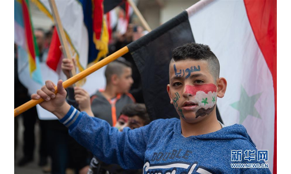 3月23日，一名戈兰高地的德鲁兹儿童举着叙利亚国旗在迈季代勒舍姆斯参加抗议活动，反对美国总统有关戈兰高地的言论。美国总统特朗普21日称，美国应承认以色列对戈兰高地的主权。连日来，一些国家和地区组织陆续发声，对此表示反对，并警告此举或引发地区局势新动荡。 新华社/基尼图片社