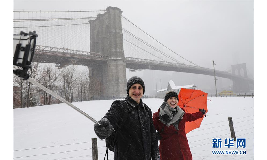 2月20日，在美国纽约布鲁克林大桥附近，游客在雪中自拍。

　　当日，纽约迎来降雪天气。

　　新华社记者 王迎 摄