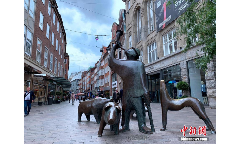 人们经过不来梅街头的雕塑。 中新社记者 彭大伟 摄