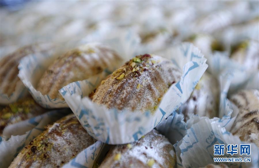 这是8月25日在黎巴嫩南部城市赛达一家甜品店拍摄的“玛阿穆勒”。“玛阿穆勒”是多个阿拉伯国家的一种传统糕点。要制作“玛阿穆勒”，首先要在面粉中加入黄油、酵母、糖等调味剂揉制、发酵；其后，再将面团分成小块，在其中塞入开心果、核桃仁、椰枣等各式果干作为馅料；最后使用模具将小块面团压制成型，放入烤箱烤制。每逢节庆，当地糕点店铺会特别制作“玛阿穆勒”等糕点供客人选购，有些家庭也会自制这种糕点。每当亲朋好友互相拜访时，主人家便会拿出准备好的“玛阿穆勒”，和客人一起享用，闲话家常，共叙情谊。新华社发（比拉尔·贾维希摄）