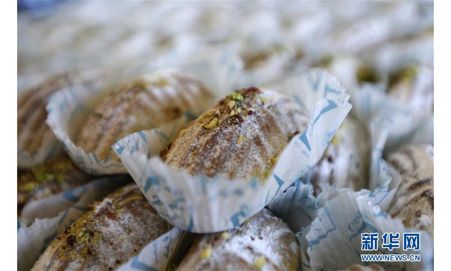 这是8月25日在黎巴嫩南部城市赛达一家甜品店拍摄的“玛阿穆勒”。“玛阿穆勒”是多个阿拉伯国家的一种传统糕点。要制作“玛阿穆勒”，首先要在面粉中加入黄油、酵母、糖等调味剂揉制、发酵；其后，再将面团分成小块，在其中塞入开心果、核桃仁、椰枣等各式果干作为馅料；最后使用模具将小块面团压制成型，放入烤箱烤制。每逢节庆，当地糕点店铺会特别制作“玛阿穆勒”等糕点供客人选购，有些家庭也会自制这种糕点。每当亲朋好友互相拜访时，主人家便会拿出准备好的“玛阿穆勒”，和客人一起享用，闲话家常，共叙情谊。新华社发（比拉尔·贾维希摄）