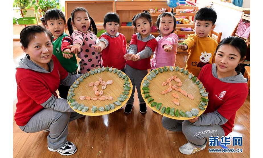 11月6日，在廊坊市安次区北大附属幼儿园，老师与小朋友在展示包好的饺子。 新华社记者王晓摄