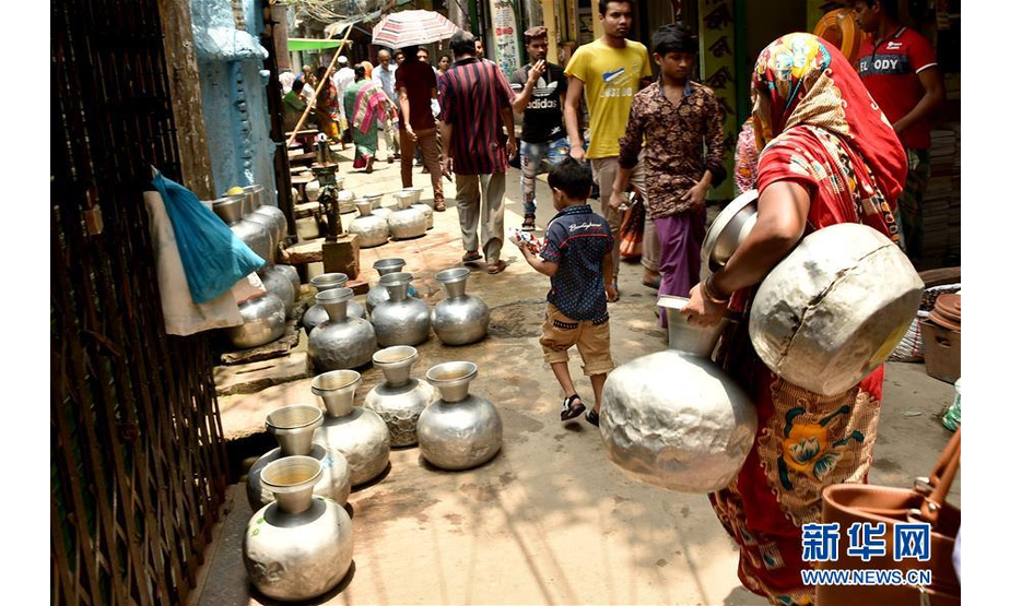 5月20日，在孟加拉国首都达卡，人们将水罐放在管井处取水。由于近一个月的热浪侵袭以及几乎没有降雨，孟加拉国首都达卡老城区市民面临供水危机。新华社发