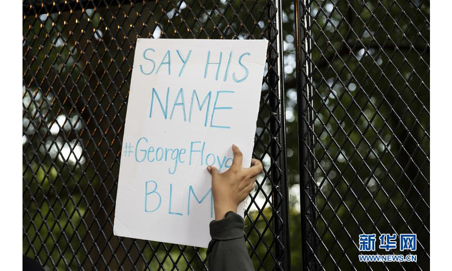 6月2日，一名示威者手举写有乔治·弗洛伊德的名字的标语在美国华盛顿白宫前抗议。 新华社发（沈霆摄）