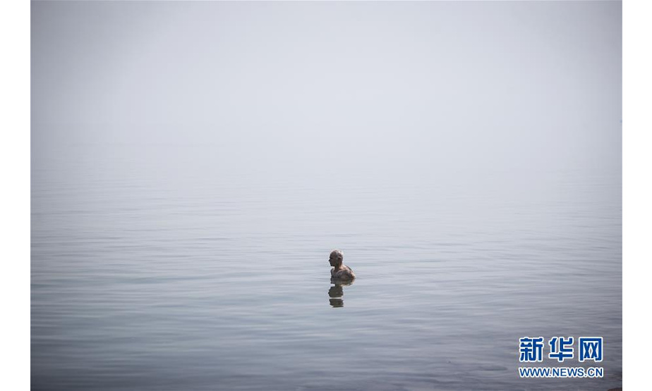 6月17日，一名游客在伊朗乌鲁米耶湖中。 近日，位于伊朗西北部的乌鲁米耶湖水位上升，吸引了众多游客前来游玩。 新华社发（艾哈迈德·哈拉比萨斯摄）