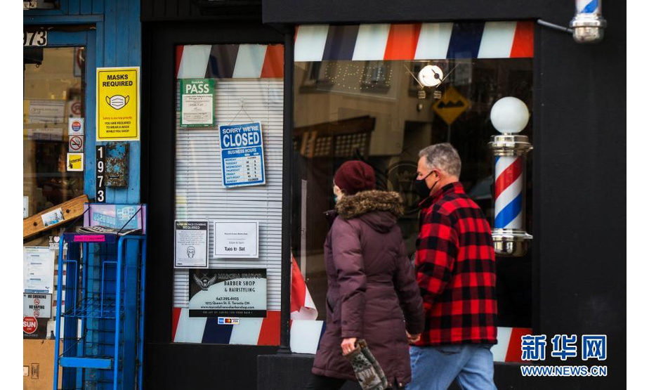 11月23日，在加拿大多伦多，戴口罩的行人路过一家关闭的理发店。

　　当日，加拿大新增新冠确诊病例5119例，多伦多等地因疫情上升再度“封城”。

　　新华社发（邹峥摄）